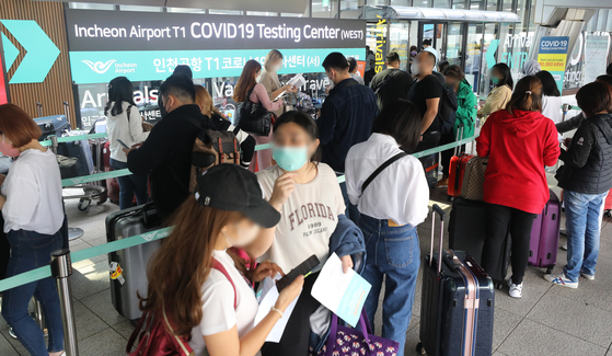 Travelers arriving at the Incheon internatiojnal airport are waiting to be tested for Covid-19 on Thursday. Korea announced the mandatory PCR tests will be scrapped for travelers starting this Saturday. [NEWS1] 