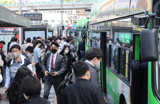 A bus stop in central Seoul is bustling with commuters on April 26, 2022. [YONHAP]