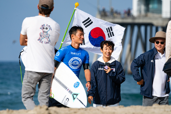 Im Su-jung, right, and her brother Im Su-hyun carry the Korean Taegukgi at the World Surfing Games in Huntington Beach, California. [INTERNATIONAL SURFING ASSOCIATION]