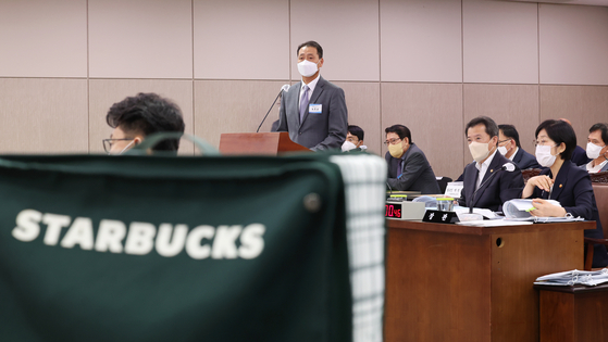 Starbucks Korea CEO Song Ho-seob answers questions from Rep. Lee Hack-young of the Democratic Party during a parliamentary hearing of the Environment and Labor Commitee at the Sejong government complex in Sejong on Tuesday. Starbucks Korea has faced public backlash this summer over the distribution of giveaway items that contained toxic chemicals such as formaldehyde. [YONHAP]