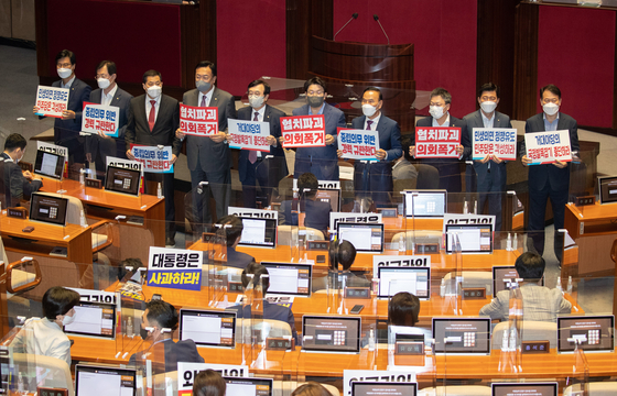 Lawmakers of the People Power Party hold up signs protesting a motion calling for the dismissal of Foreign Minister Park Jin in the National Assembly Thursday. The Democratic Party later passed the motion. [JOINT PRESS CORPS]