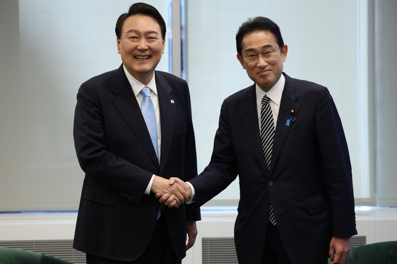 President Yoon Suk-yeol, left, and Japanese Prime Minister Fumio Kishida shake hands ahead of a bilateral meeting in New York on Sept. 21. [YONHAP]