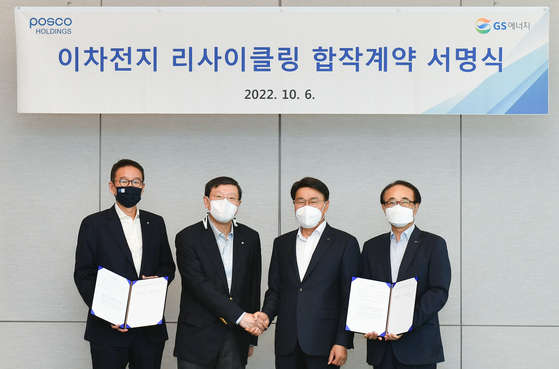 GS Group Chairman Huh Tae-soo, center left, shakes hands with Posco Group Chairman Choi Jeong-woo after signing an agreement to establish a battery recycling joint venture on Thursday at Posco Center in Gangnam District, southern Seoul. [POSCO HOLDINGS]  