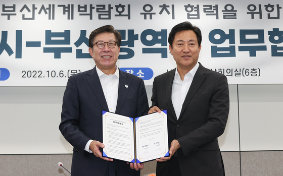 Seoul Mayor Oh Se-hoon, right, and Busan Mayor Park Heong-joon pose for a photo after signing a Memorandum of Understanding (MOU) for cooperation on Busan’s bid to host the World Expo in 2030 at Seoul City Hall on Thursday. [YONHAP]