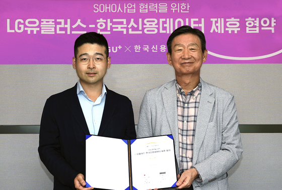 Kim Dong-ho, left, Korea Credit Data CEO, and Hwang Hyeon-sik, LG U+ CEO, pose for a photo during a signing ceremony held at the LG U+ headquarters in Yongsan District, central Seoul. [LG U+]