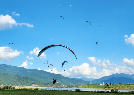 Athletes compete in the Gochang leg of the Paragliding World Cup in Gochang, North Jeolla on Wednesday. A total of 120 athletes from 22 countries are competing in the World Cup, with events set to run until Saturday.  [YONHAP]
