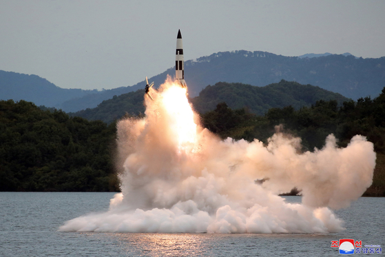 A photograph released by the KCNA shows the launch of a KN-23 short-range ballistic missile (SRBM) from an underwater platform in a reservoir during a recent test. [YONHAP]