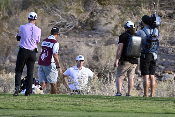 Patrick Cantlay, center, reviews his shot from the desert area off the 18th fairway during the final round of the Shriners Children's Open on Sunday in Las Vegas. [AP/YONHAP]