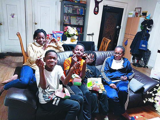 The Lulendo family holds boxes of letters and snacks offered by elementary school students from a nearby church on Monday at their home in Ansan, Gyeonggi. The father, Nkuka Lulendo, is in Congo receiving traditional healing practices from his mother for physical pain. [HONG JOO-MIN]