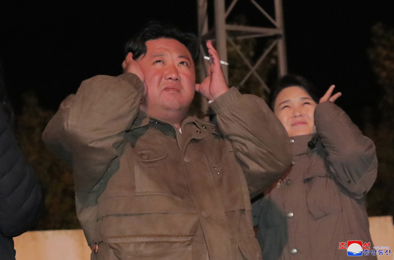 North Korean leader Kim Jong-un and his wife Ri Sol-ju cover their ears while watching a recent missile launch in this photo released by the state-run Korean Central News Agency (KCNA) on Monday. [YONHAP]