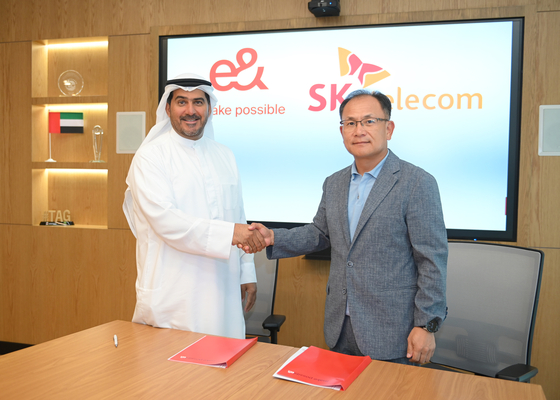 e& life CEO Khalifa Al Shamsi, left, and SK Telecom Chief Development Officer Ha Min-yong shake hands after signing a memorandum of understanding at the e& headquarters in Dubai on Wednesday. [SK TELECOM]