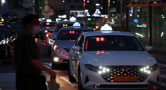 A passenger waits for a taxi near Seoul Station, central Seoul. [YONHAP]