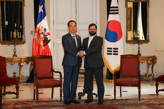 Prime Minister Han Duck-soo, left, and Chilean President Gabriel Boric pose for the camera before holding talks on Tuesday. [YONHAP]