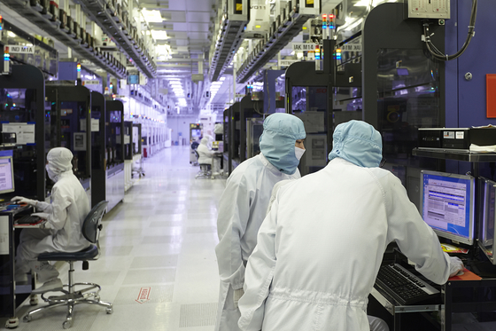 Engineers work at a SK hynix production line. [SK HYNIX]