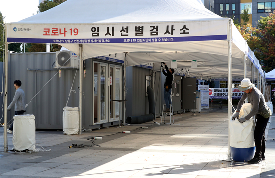 Workers dismantle a testing center in front of Incheon City Hall Thursday as the number of Covid-19 cases declined in recent weeks. [YONHAP]