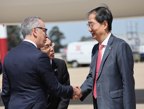 Prime Minister Han Duck-soo, right, is greeted by a Uruguayan official after arriving in Montevideo for an official visit on Wednesday. [YONHAP]