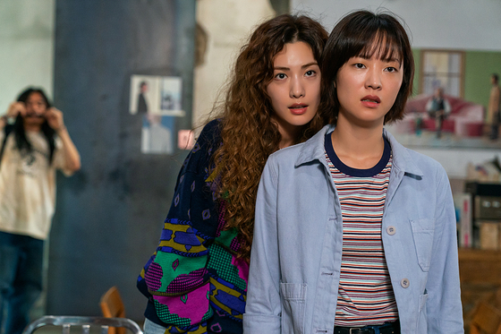 Jeon Yeo-been, right, portrays the protagonist who witnesses aliens and UFOs in Netflix sci-fi mystery series “Glitch.” When her boyfriend goes missing, she and her childhood best friend become convinced that he has been kidnapped by aliens. Singer and actor Nana portrays the best friend. [NETFLIX]