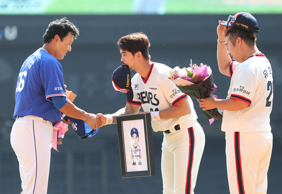 Former Doosan Bears stars Oh Jae-won, center, and Yoo Hee-kwan, right, present gifts to Lee Seung-yuop during a retirement ceremony at Jamsil Baseball Stadium in Seoul on Sept. 3, 2017.  [YONHAP]