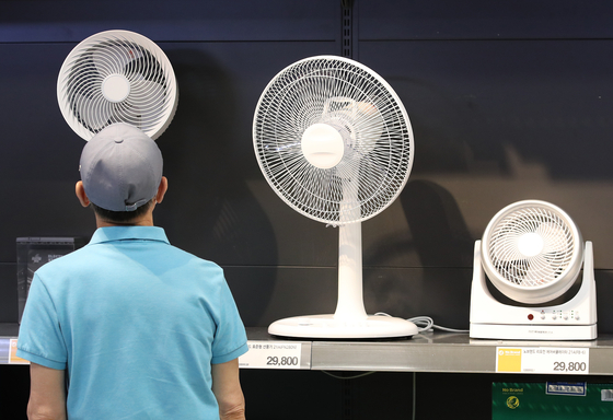 A shopper looks around a display of electric fans at a large mart in Seoul on June 20, 2021. [NEWS1]
