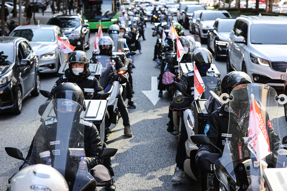 Delivery riders, who are also union members of delivery platform service providers under the Korean Confederation of Trade Unions, protest in front of Coupang’s headquarters in Songpa District, southern Seoul, on Tuesday. The delivery riders said they are going on strike, demanding that the food delivery platform Coupang Eats raises their basic rates. [YONHAP]