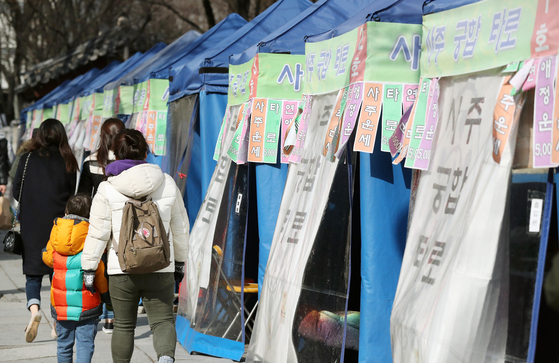 People walk by rows of tents set up by fortune-tellers in Jongno District, central Seoul, on Feb. 24, 2017. [YONHAP]
