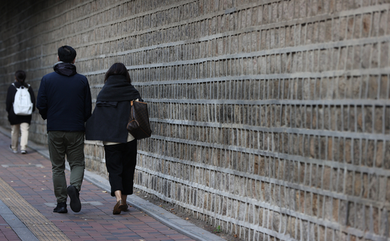 A couple walk hand-in-hand on the Deoksugung Stonewall Path in Jung District, central Seoul, on Oct. 21, 2021. [YONHAP]