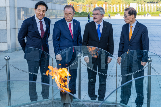 From left, Seoul Mayor Oh Se-hoon, former U.N. Secretary-General Ban Ki-moon, International Olympic Committee Chief Thomas Bach and Korea Sports Promotion Foundation Chairman Cho Hyun-jae look at the Eternal Flame which has been burning since 1988 Seoul Olympics at World Peace Gate at Olympic Park in southern Seoul on Tuesday. [YONHAP]