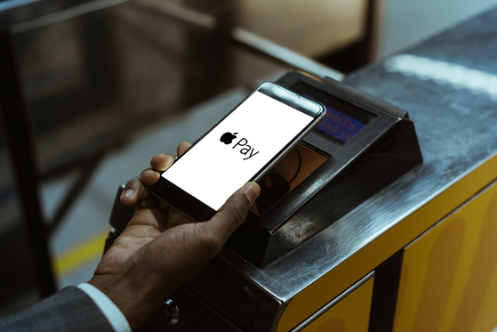 A close-up of a man using Apple Pay to pay for public transportation [SHUTTERSTOCK]