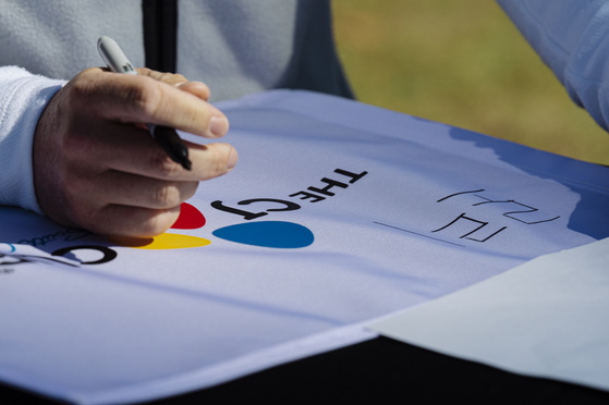 Rory Mcilroy writes his name in Korean letters, hangul, on Wednesday morning ahead of the CJ Cup at Congaree Golf Club in Ridgeland, South Carolina. [GETTY IMAGE FOR THE CJ CUP]