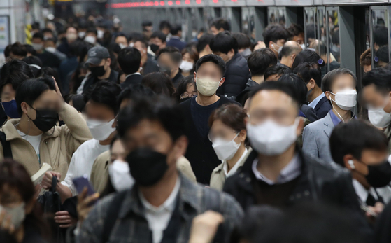 People walk with their masks on at a platform in Gwanghwamun Station in Jongno District, central Seoul, on Friday. [NEWS1] 