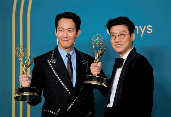 Lee Jung-jae, winner of the Emmy for Outstanding Lead Actor in a Drama Series for ″Squid Game,″ left, and Hwang Dong-hyuk, winner of the Emmy for Outstanding Directing for a Drama Series for ″Squid Game,″ pose for photos with their trophies in hand at the 74th Primetime Emmy Awards on Monday at the Microsoft Theater in Los Angeles. [AP/YONHAP]