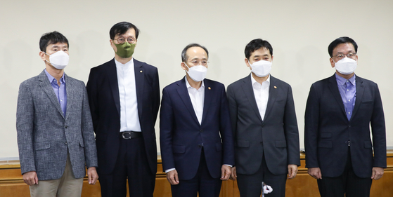 Finance Minister Choo Kyung-ho, center, and Financial Services Commission Chairman Kim Joo-hyun, second from right, pose with other officials as they enter a meeting held in central Seoul on Sunday to discuss market stabilization measures. [BANK OF KOREA]