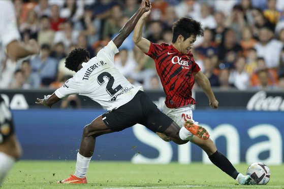Mallorca's Lee Kang-in, right, vies for the ball with Valencia's Thierry Correia during a La Liga game at the Mestalla Stadium in Valencia, Spain on Saturday. [EPA/YONHAP]