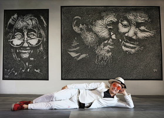 GuGu Kim poses in front of his large paintings that depict the rich inner life of humans with monotone colors [PARK SANG-MOON]