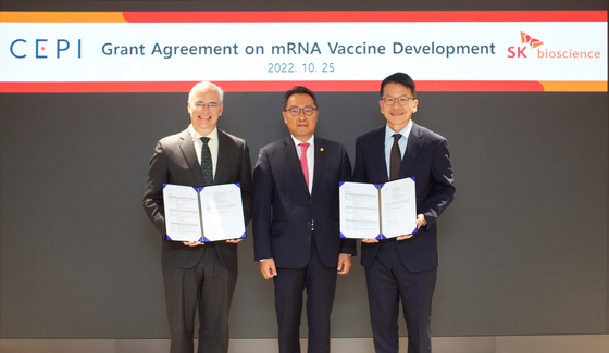 From left, Richard Hatchett, CEO of CEPI, Park Min-soo, second vice minister of the Health and Welfare Ministry, and Chey Chang-won, vice chairman of SK discovery, pose for a photo after signing an agreement on the cooperation of developing mRNA technology Tuesday at Grand Walkerhill Seoul in eastern Seoul. [SK BIOSCIENCE] 