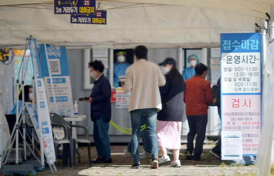People stand in line to get tested for Covid-19 at a testing center in Daejeon on Monday. [JOONGANG ILBO]