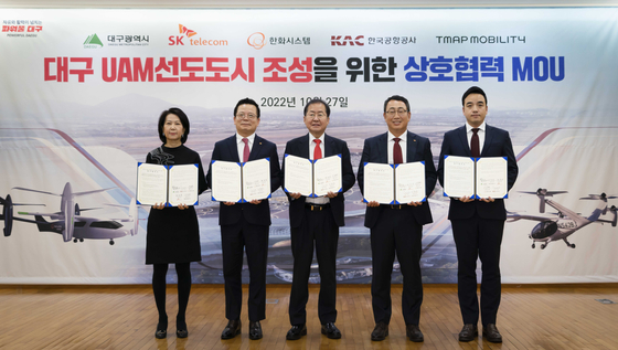 Daegu Mayor Hong Joon-pyo, center, and SK Telecom CEO Ryu Young-sang, second from left, pose during a signing ceremony in Daegu Thursday with representatives of Tmap Mobility, Hanwha Systems, and Korea Airports Corporation. [SK TELECOM]