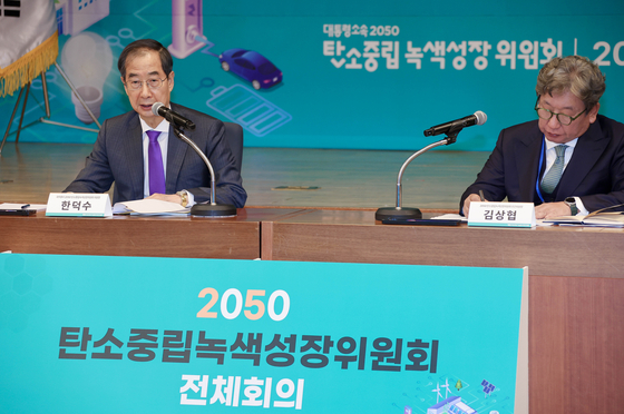 Prime Minister Han Duck-soo, left, speaks at a meeting on carbon neutrality on Oct. 26. [YONHAP]