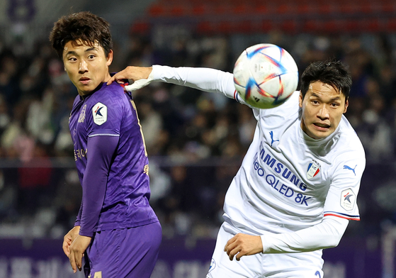 The Suwon Samsung Bluewings' Yang Sang-min, right, and FC Anyang's Hong Chang-beom vie for the ball during the first leg of the K League promotion-relegation playoffs held at Anyang Sports Complex in Anyang, Gyeonggi on Wednesday. [NEWS1] 