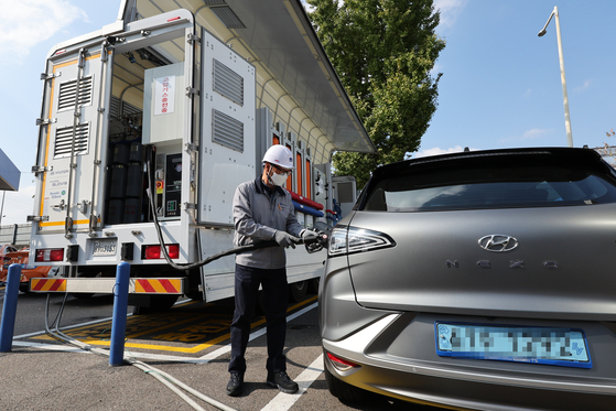 Hydrogen gas is pumped into a vehicle from a mobile charging station on a 25-ton Hyundai Motor Xcient truck in Seoul on Friday. The Korean automaker launched the country’s first mobile hydrogen fuel charging station. A single such truck has the capacity to service 50 vehicles per day. [YONHAP] 