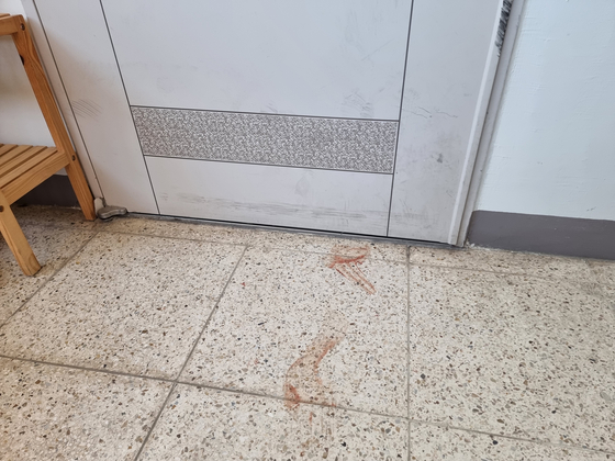Bloody footprints outside the door of an apartment unit in Gwangmyeong, Gyeonggi where a man allegedly killed his wife and two sons on Tuesday night. [LEE BYUNG-JUN]
