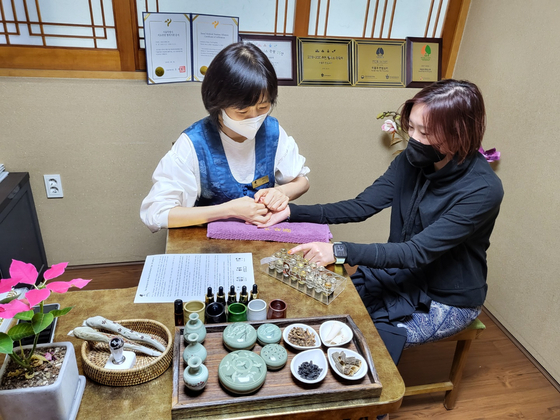 Zio Choi, the manager at Yeo Yong Kuk spa tests Karen Lee's Sasang constitution type before her treatments. Lee is visiting Korea from Hong Kong. [YIM SEUNG-HYE] 