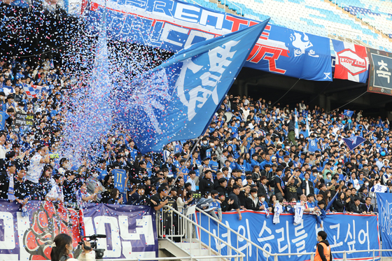 Suwon Samsung Bluewings fans celebrate beating FC Anyang 2-1 in the second leg of the playoffs at Suwon World Cup Stadium in Suwon, Gyeonggi on Saturday to keep their spot in the K League 1. [NEWS1]