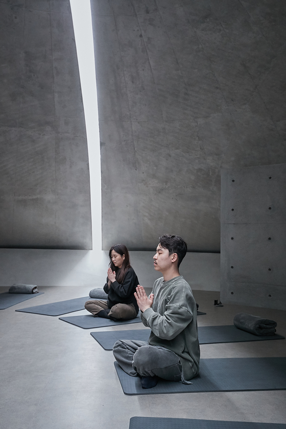 Visitors mediate under natural light at the Meditation Hall of the Museum SAN. [MUSEUM SAN]