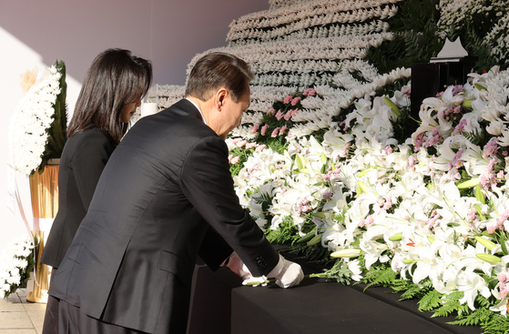 President Yoon Suk-yeol and first lady Kim Keon-hee visit a mourning altar for the victims of last weekend's Halloween crowd crush at Seoul Plaza in central Seoul on Oct. 31. [YONHAP]