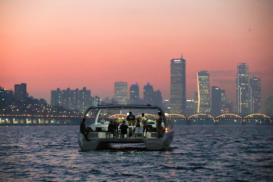 People watch the sunset from a yacht on the Han River on Nov. 12, 2020. [JOONGANG ILBO] 