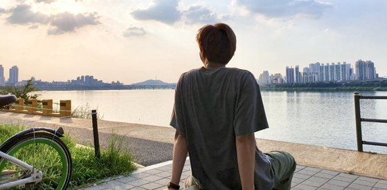 BTS's RM sits by the Han River during the boy band's two-month vacation in August 2019. [SCREEN CAPTURE]