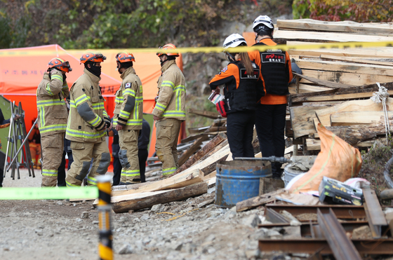 Firefighters on Monday try to rescue two men trapped in a zinc mine in Bonghwa County, North Gyeongsang. The mine collapsed on Oct. 26. [YONHAP]