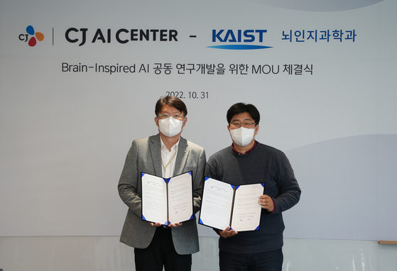 Lee Chi-hoon, left, head of CJ AI Center, and Jeong Jae-seung, head of the brain cognitive science department at KAIST, pose for a photo during a signing ceremony held Monday in Gangnam District, southern Seoul. [CJ CORP]