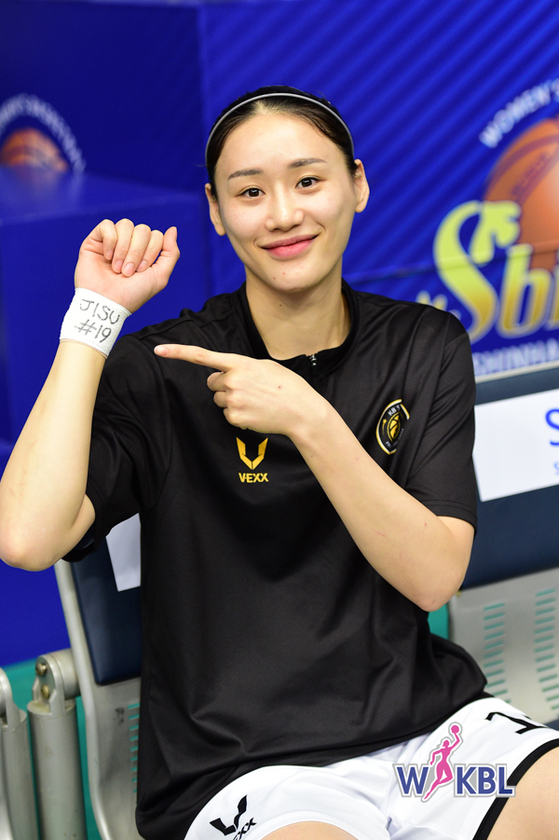 Cheongju KB Stars' Kang Lee-seul points to her wrist band with teammate Park Ji-su's name written on it on Sunday before a WKBL match against Shinhan Bank at Dowon Stadium in Incheon. [WKBL]